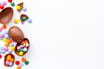 Happy Easter flat lay of chocolate eggs and sweets, top view