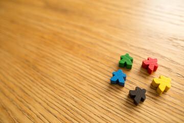 Diversity of people on wooden background. Board game concept. Meeple