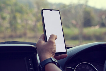 The hand of driver is using a mobile phone to help navigate or GPS while parking on the side of the...