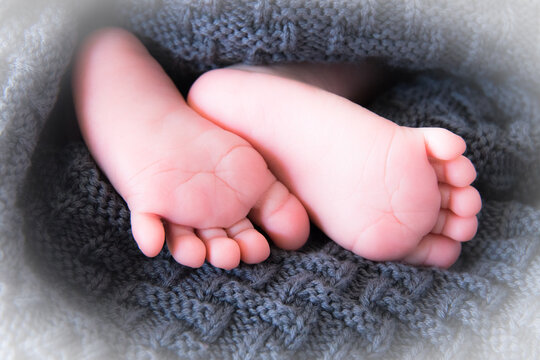 S&uuml;&szlig;e kleine Babyf&uuml;&szlig;e in grauer Decke bei einem Babyshooting 