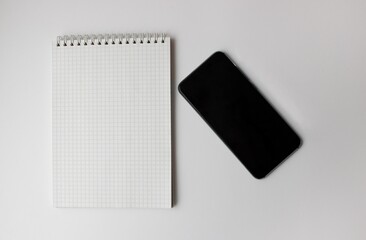 notebook and smartphone lie on a gray background