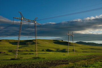 Fototapeta na wymiar Russia. Republic of Khakassia. Illuminated by the morning sun, power transmission poles in the endless steppes.