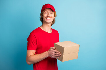 Photo of half turned cheerful person toothy smile arms hold headwear isolated on blue color background