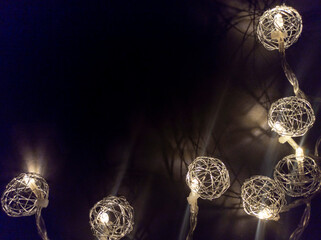 Photo of New Year's lighting on a black background. Awesome garland decoration. Festive decoration for Christmas and New Year. Low key. View from above.