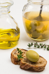 Green olive on slice of bread. Jar of olives