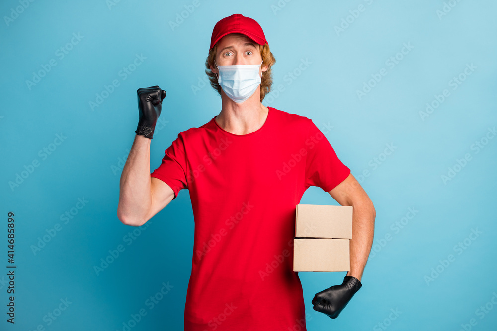 Sticker photo of strong postman hold carton boxes fist up wear medical healthcare mask isolated on blue colo