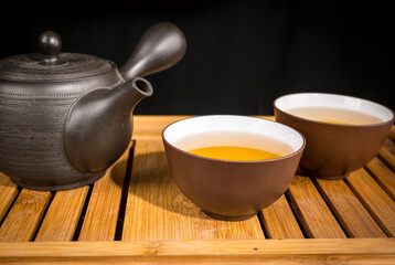 preparation of green loose tea in traditional Japanese ceramics - obrazy, fototapety, plakaty