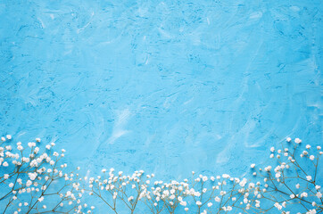 White flowers on a blue background. Spring flowers background top view. Banner with copy space