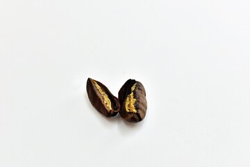 roasted coffee beans cut in haft on background white