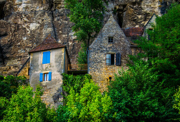 Casas de piedra con llamativas ventanas, incrustadas en la roca y entre la vegetación