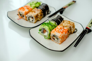 Several sushi on a white plate standing on a white background
