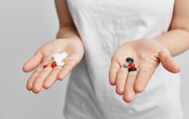 brunette in a white t-shirt with pills in her hands health problems