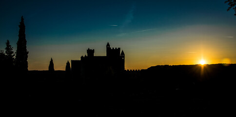 Obraz premium Castillo medieval francés recortándose al atardecer sobre el cielo dorado y azul