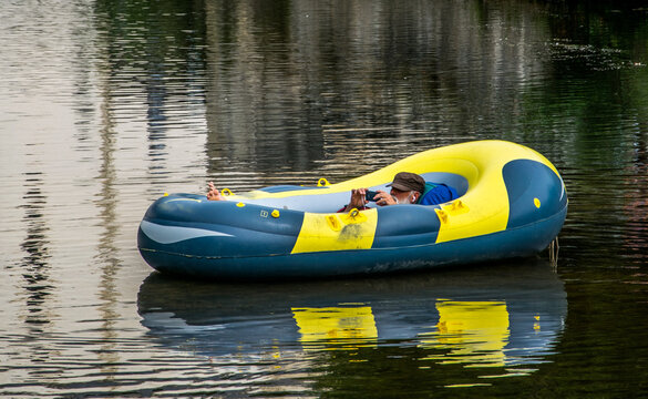 Un hombre de largas barbas blancas descansa flotando en un río sobre un bote hinchable 