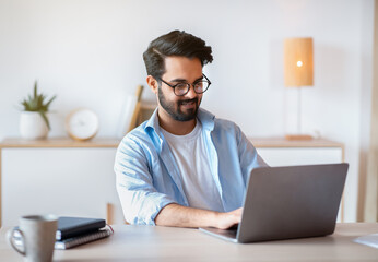Smiling Arab Man Self-Entrepreneur Working With Laptop At Home Office