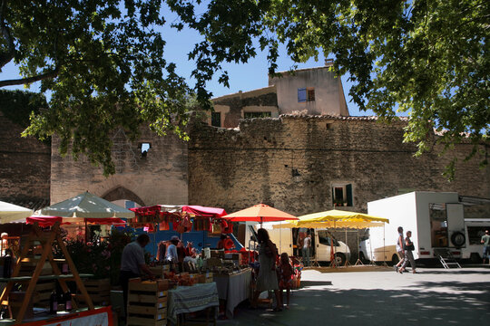 Cucuron, Vaucluse, Provence-Alpes-Cote d'Azur, France: market stalls and coloured sunshades by the old fortifications