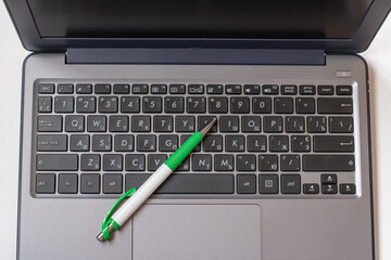 Laptop keyboard black on gray background with a pen on it. Close-up of laptop keyboard.