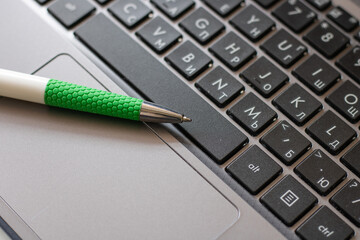Laptop keyboard black on gray background with a pen on it. Close-up of laptop keyboard.