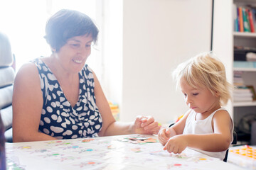 Grandmother, teaching her grandson alphabet and numbers, educating