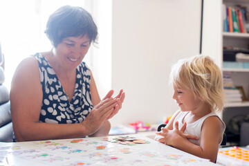 Grandmother, teaching her grandson alphabet and numbers, educating