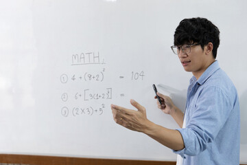 Asian teachers are teaching mathematics classes in addition, subtraction, multiplication, and division in high school or university classrooms, math quiz on a white board.