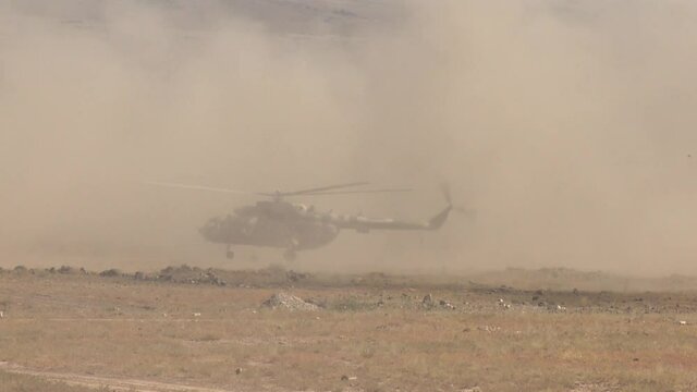 military soldiers jump out of the helicopter, carrying out a special operation in the desert, landing