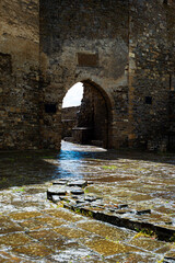 An ancient fortress from the inside. Stone walls and floor. Arch with light.