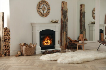 Beautiful fireplace and basket with firewood in contemporary room interior