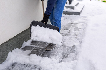 Snow removal of the driveway in front of the house with a shovel