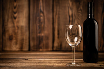 Red wine glass and bottle red wine on old wooden background. 