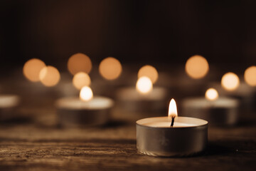 Close-up image of many burning candles in the dark. Bokeh effect background.