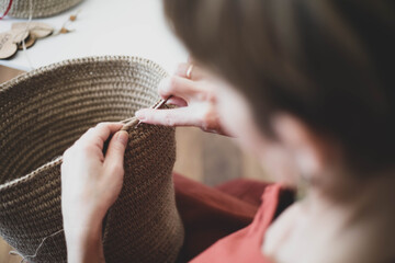 The woman is crocheting from environmentally friendly materials. Jute fiber for home decor. Home...