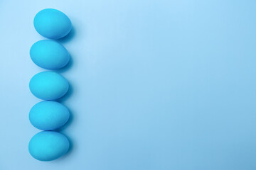 Easter eggs lined up on a blue background with room for text