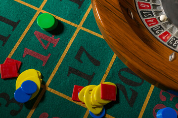 Roulette in legno isolata sopra un tavolo da gioco verde con fiches colorate
