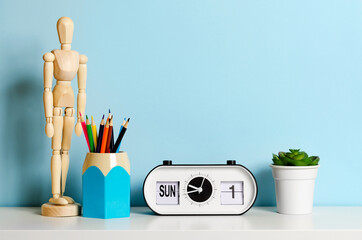 Concept of school items on the home desk on a blue background. Place for text.