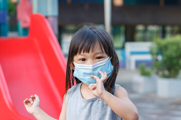Portrait image of 2-3 yeas old baby. Happy Asian child girl smiling and wearing fabric mask,​ She...