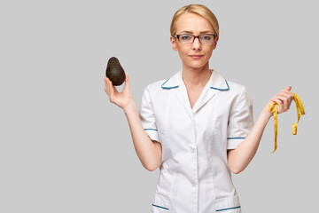 nutritionist doctor healthy lifestyle concept - holding organic avocado fruit and measure tape