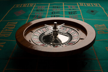 Roulette in legno isolata sopra un tavolo da gioco verde