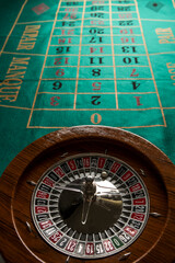 Roulette in legno isolata sopra un tavolo da gioco verde - obrazy, fototapety, plakaty