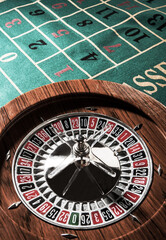 Roulette in legno isolata sopra un tavolo da gioco verde - obrazy, fototapety, plakaty