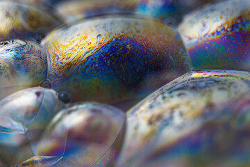 Abstract texture with bubbles. Rainbow soap bubble on a black background. Close-up of a colorful surface.