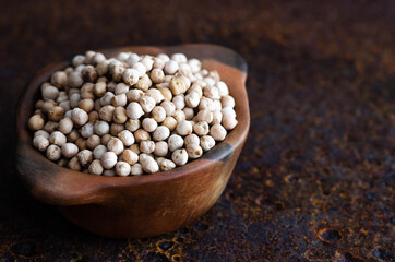 Chickpeas in a bowl on a dark background. 