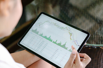 Business woman hand holding digital tablet computer with graph of Binary option for trading platform, setective focus
