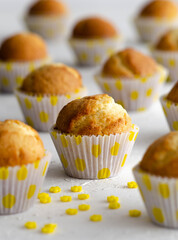Lemon muffins with yellow sugar flowers on a white background. 