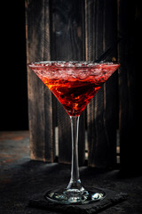 Red alcoholic cocktail with tequila, strawberry syrup and crushed ice, in a cocktail glass