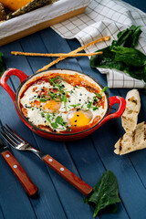 Shakshuka is a traditional Israeli dish of eggs with tomato sauce and vegetables in a frying pan, Breakfast