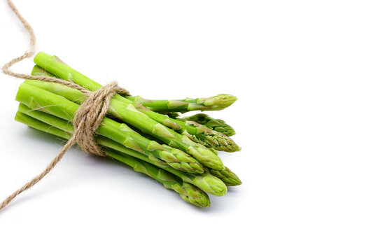 Fresh green asparagus With a rope tied in the middle isolated on white background.