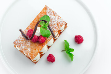 raspberry mille feuille dessert with whipped sour cream on a white plate