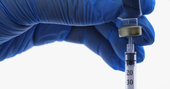 Medical nurse hand in safety gloves holds a syringe and vaccine bottle. Doctor uses hypodermic needle and a syringe to put a shot of drug as treatment. Health and medical concepts. Clinic hospital.