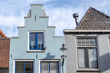 Colroful gable house with blue windows and door and colroful light blue wall